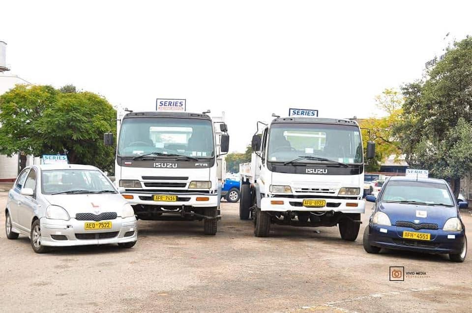Series Driving School cars and trucks lined up in the training yard