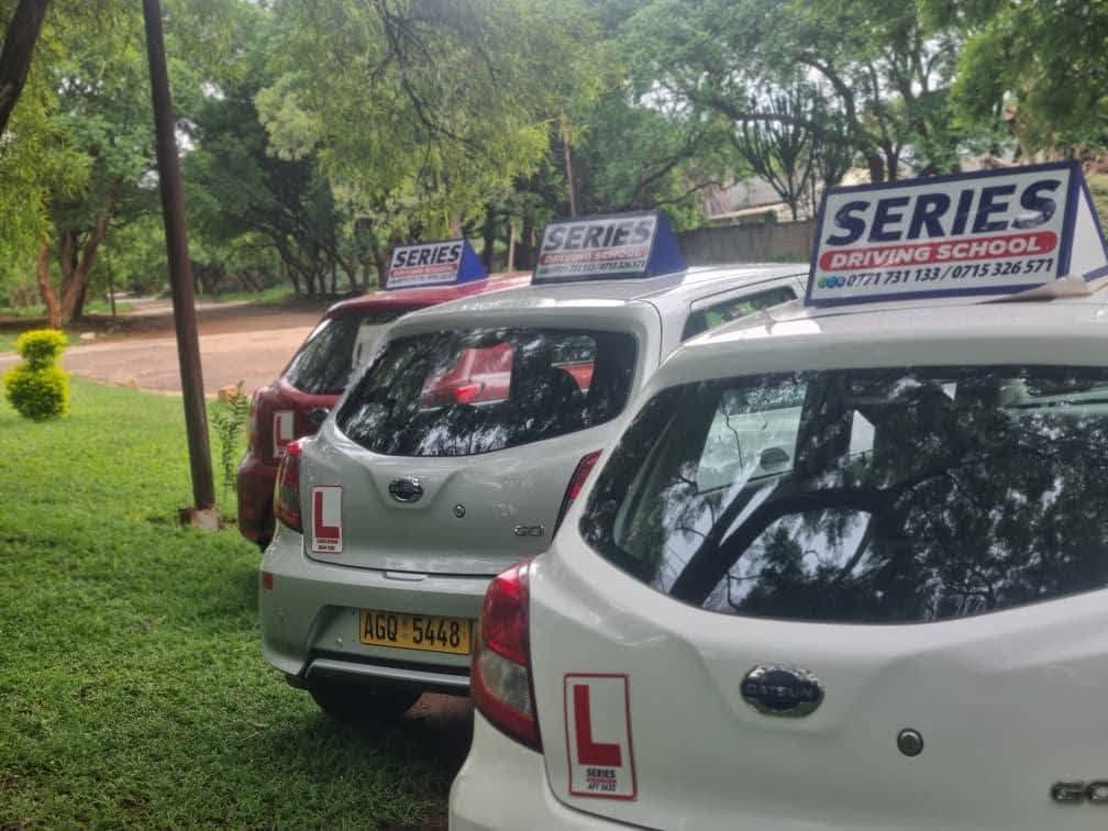 Series Driving School learner cars parked under trees